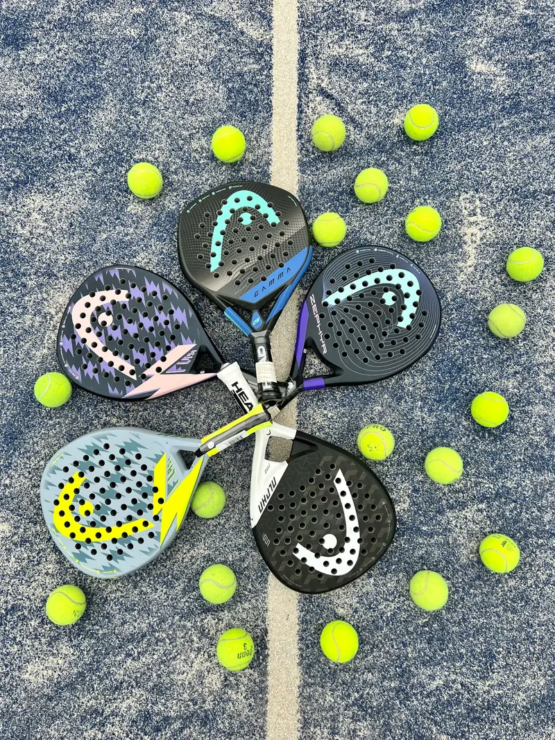 Padel rackets and balls arranged on a court.